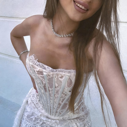 Woman wearing a white lace dress with a blurred background