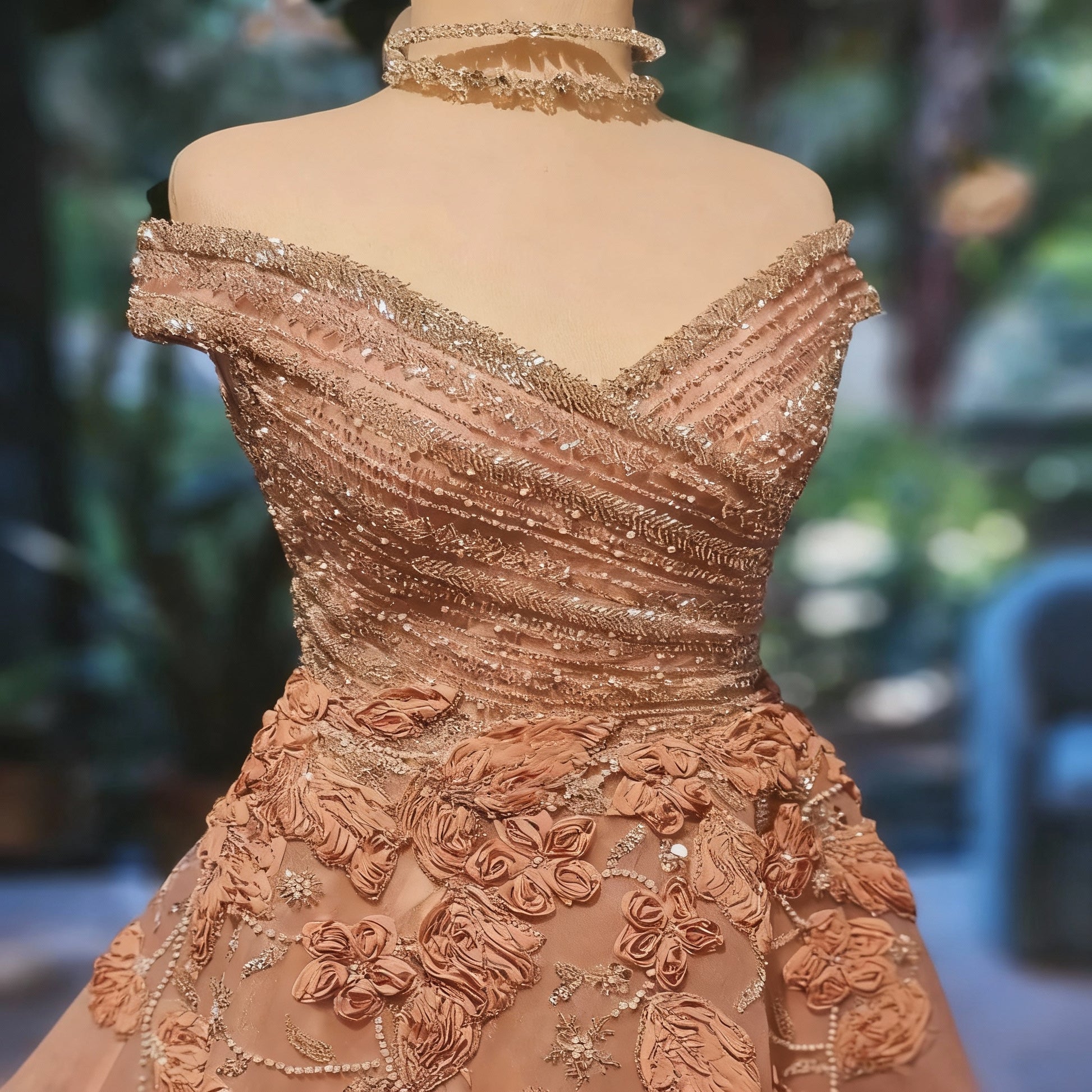 Elaborately designed off-shoulder dress with floral and bead details on a blurred background
