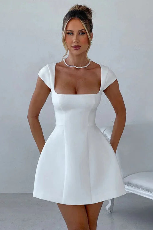 Woman wearing a white dress against a plain background