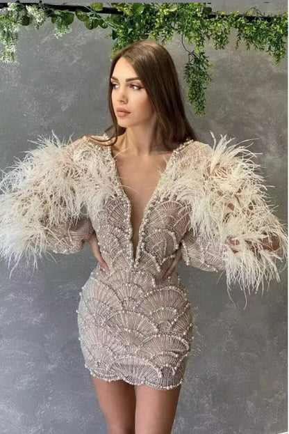 Woman wearing a lace dress with feathered sleeves against a gray background