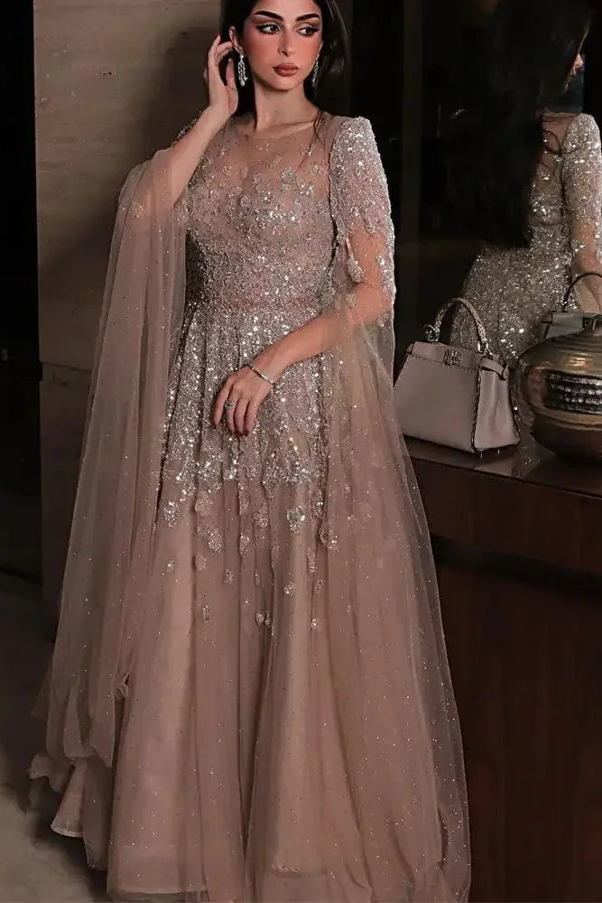 Woman in a sparkly dress standing next to a wooden cabinet with decorative items.