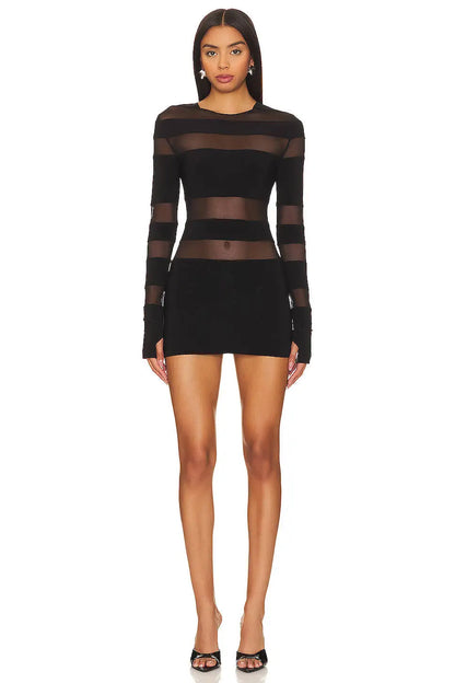 Black dress with sheer panels worn by a model on a white background