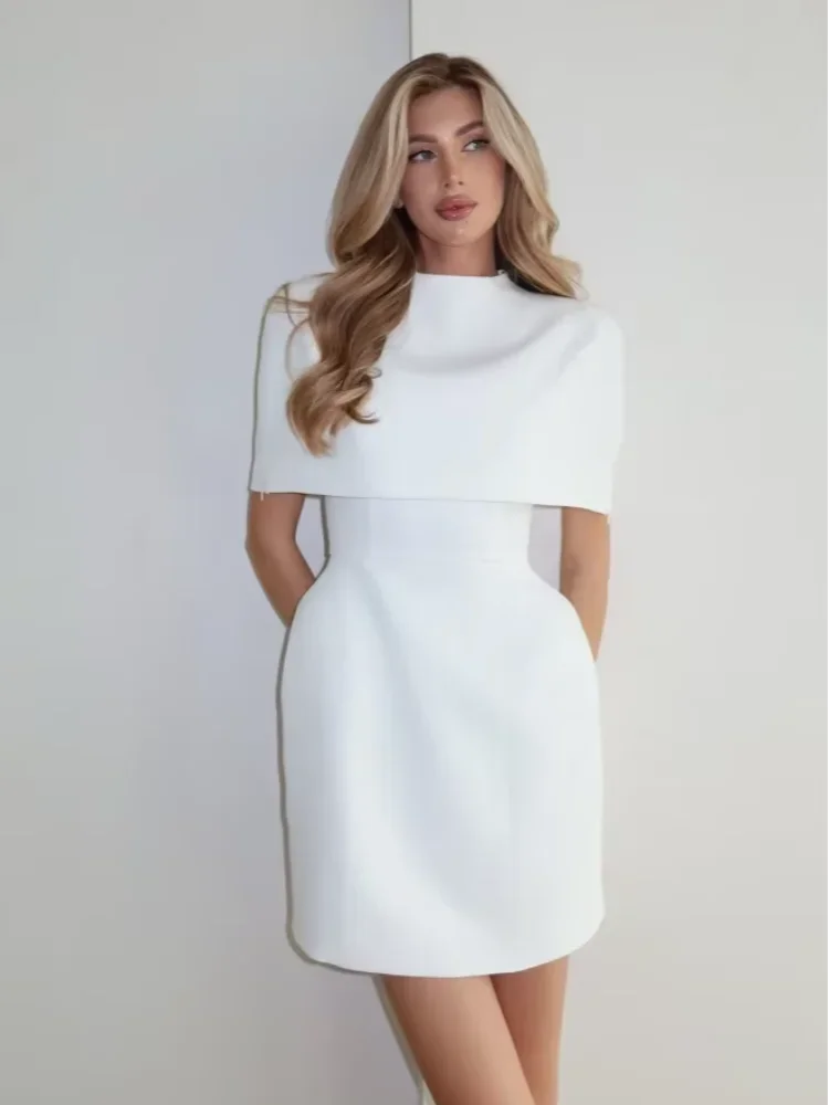 Woman wearing a white dress against a plain background
